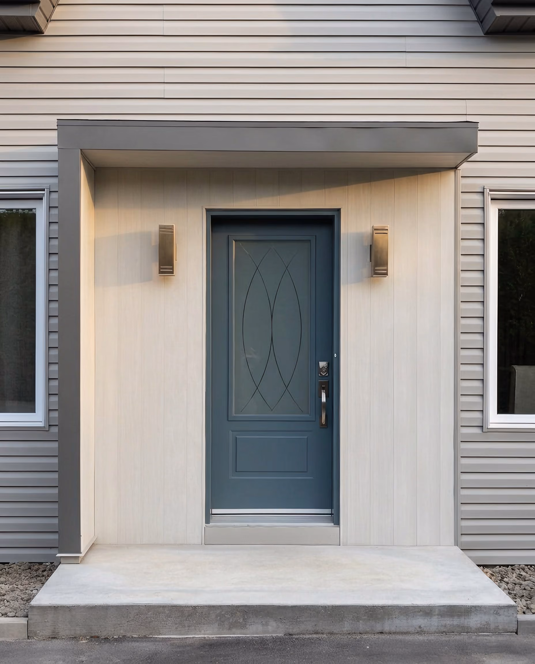 Porte d’entrée contemporaine bleu-gris avec vitrage décoratif, marche de béton.
